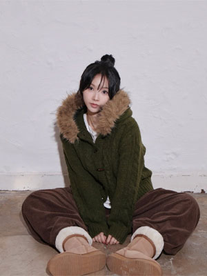 Woman in a green fur-collar knit jacket and brown corduroy pants wearing tan platform ugg boots