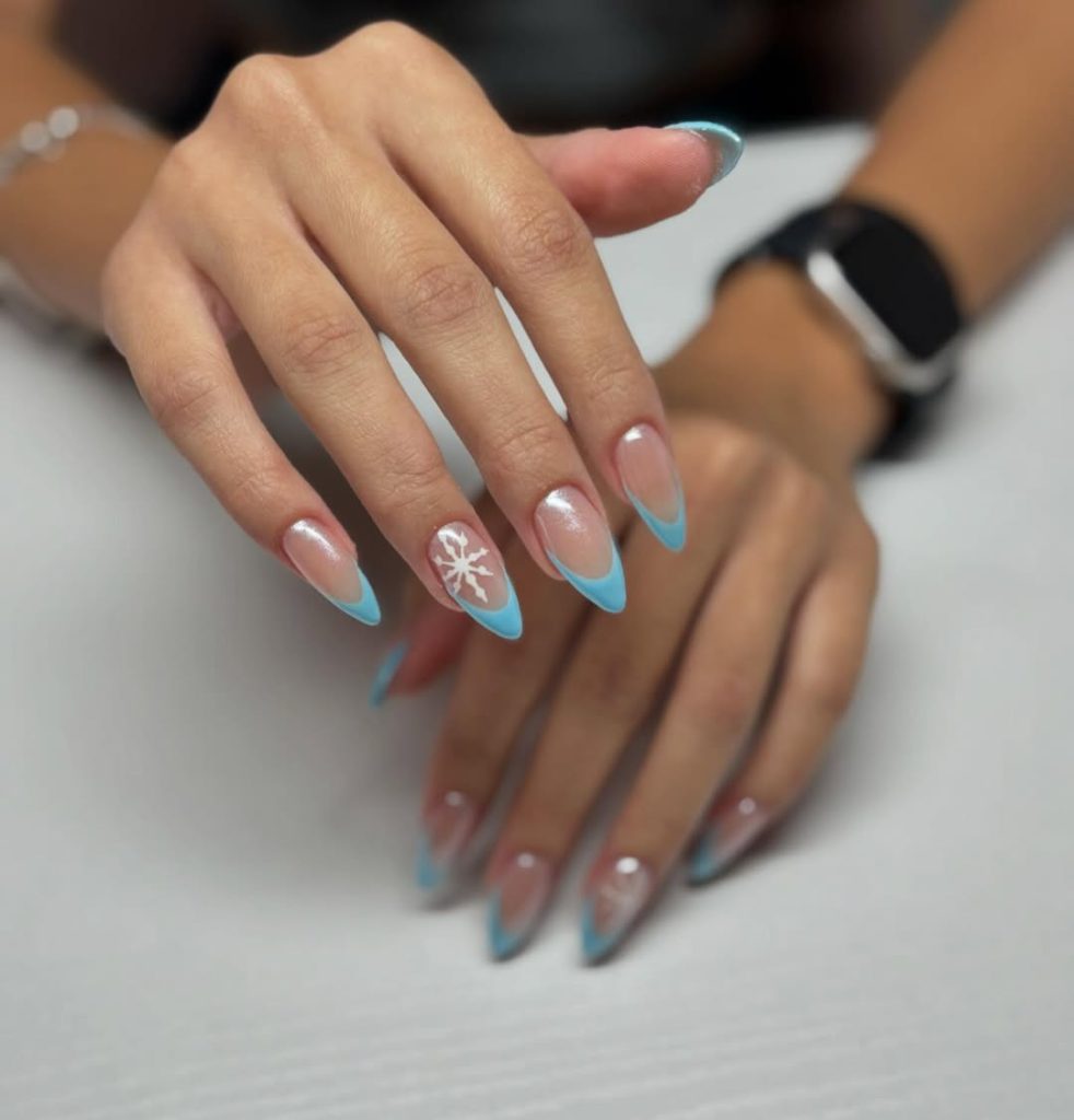 Light blue French tip nails with snowflake accent