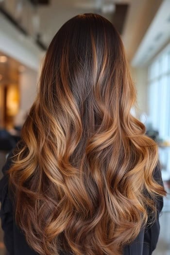 Caramel balayage on long wavy hair seen from behind