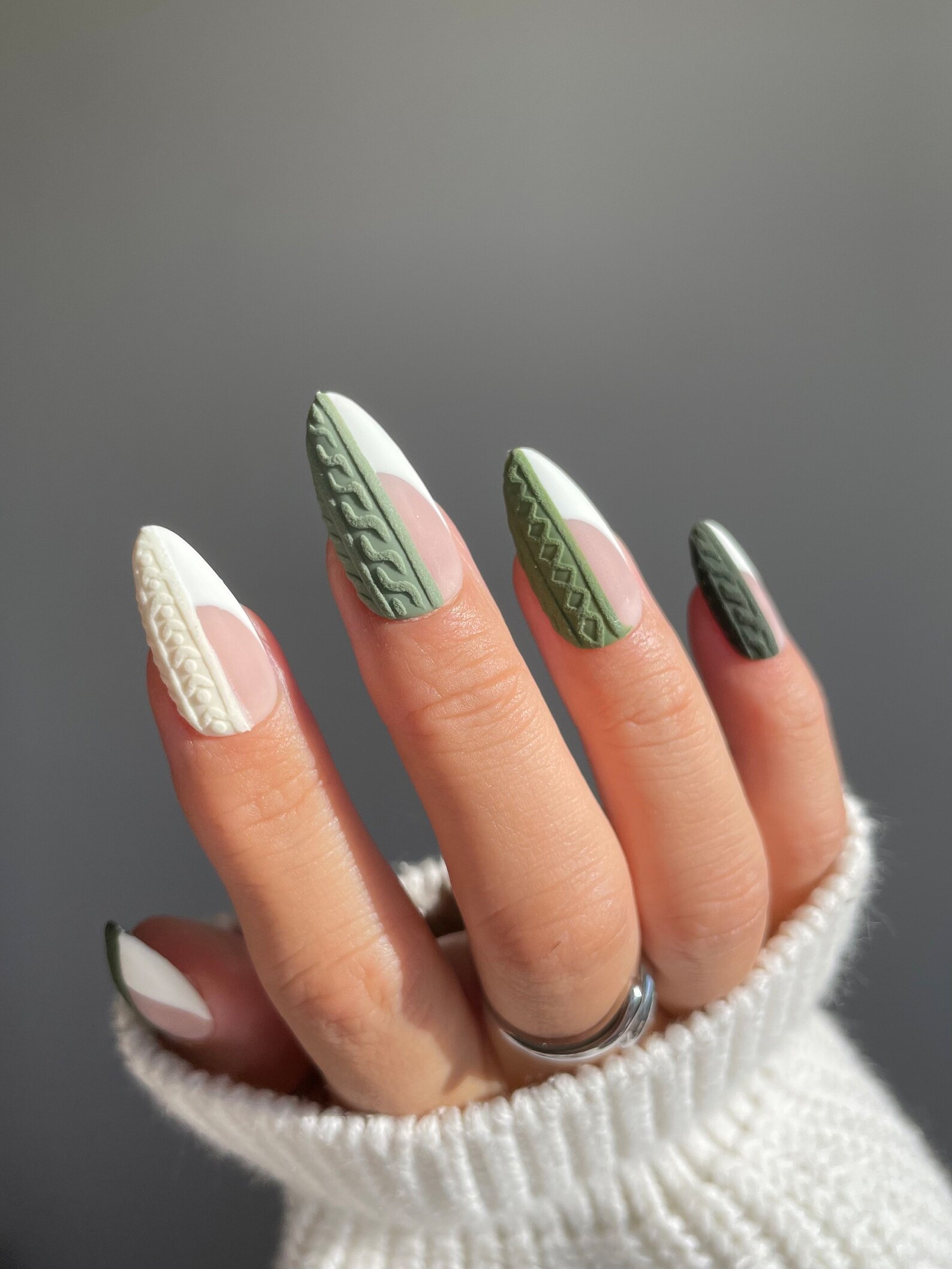 Almond nails with white French tips and raised sage green cable-knit texture