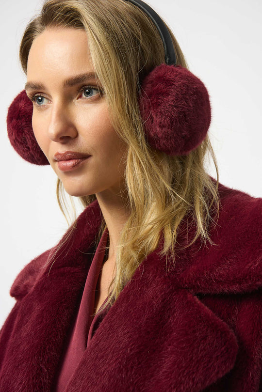 Woman in burgundy faux fur earmuffs and a matching burgundy faux fur coat