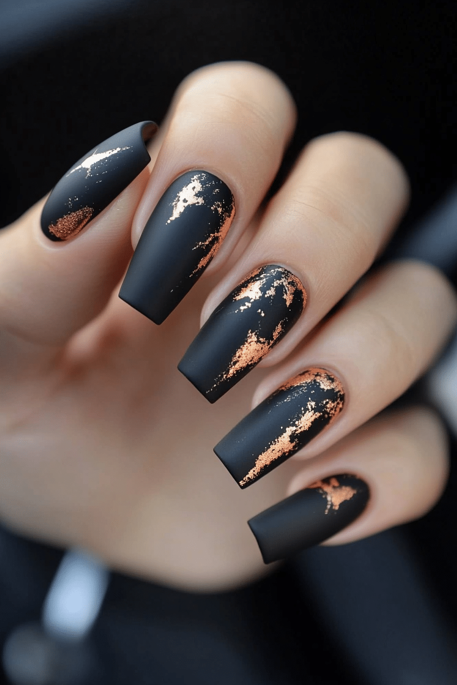 Long coffin nails in matte black with copper and rose gold foil streaks