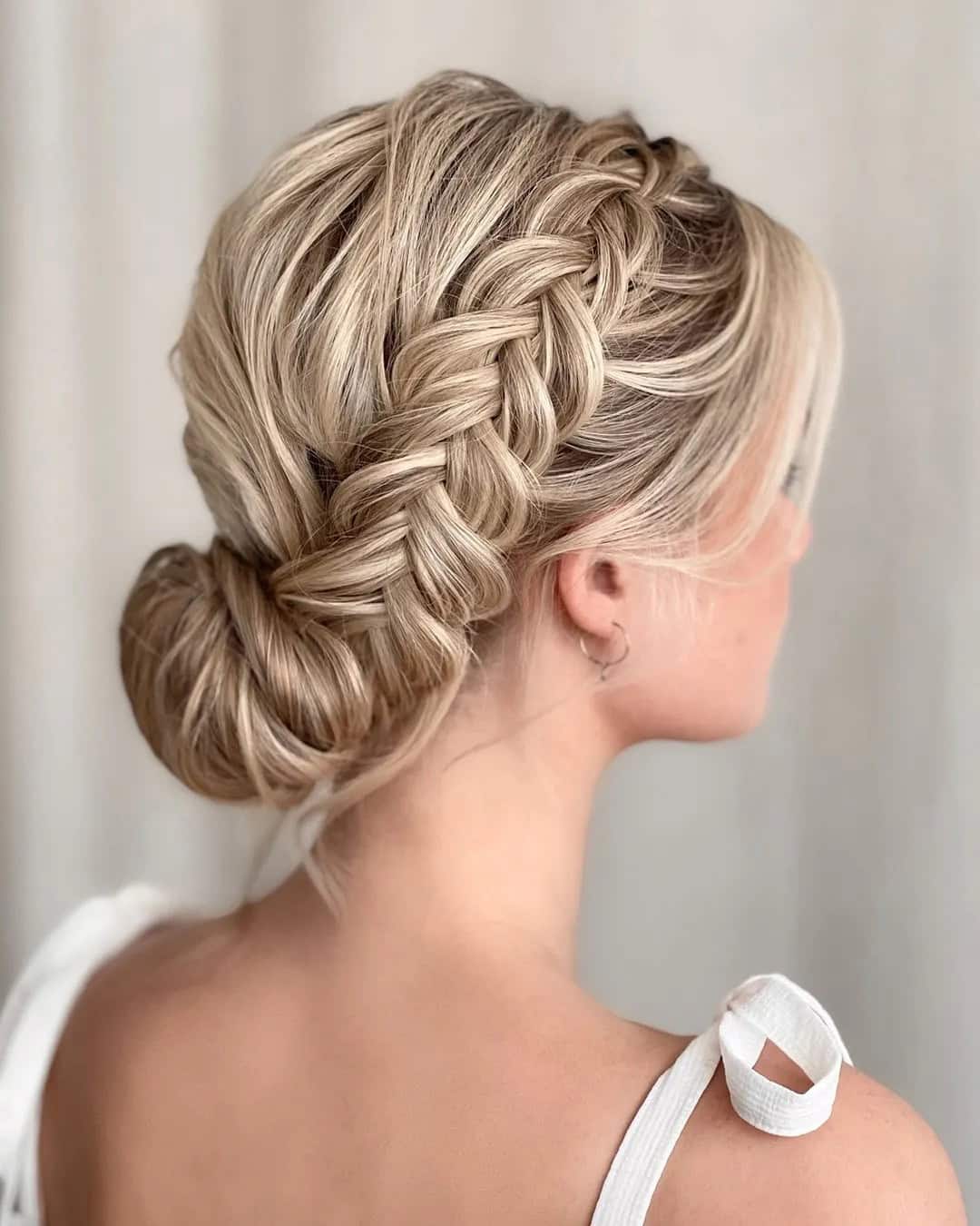 A smooth low bun wrapped with a neat braid