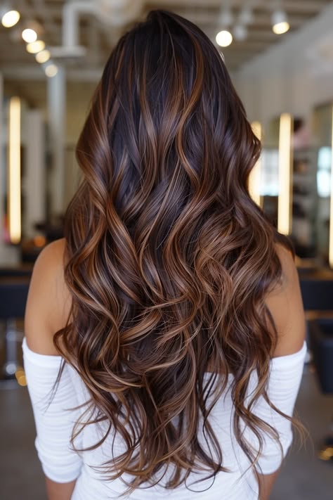 Dark brown hair with caramel balayage, long wavy layers