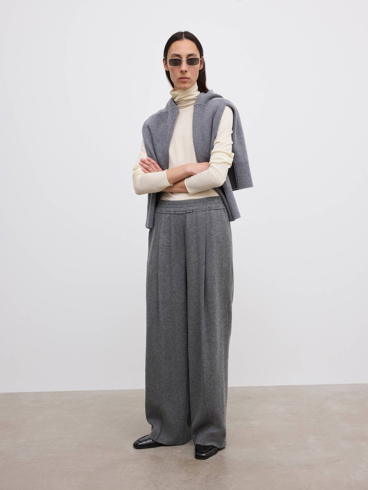 Wide-leg gray wool trousers as the base of a tonal layered knit outfit