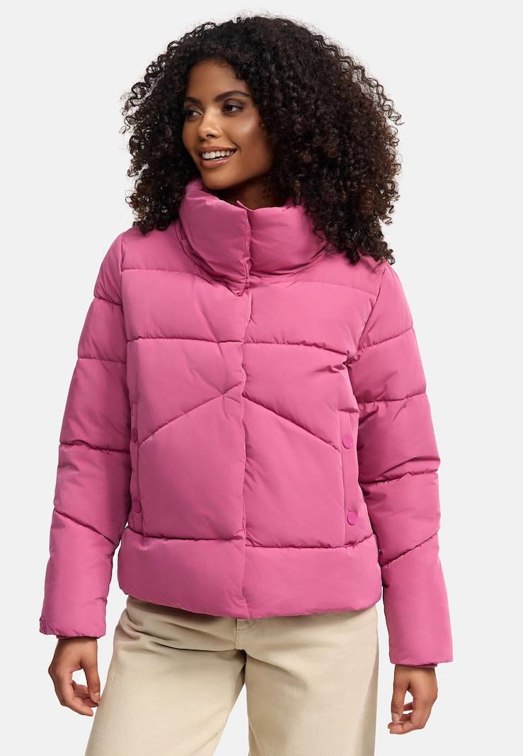 A mauve-pink funnel-neck puffer jacket with snap-button details, worn with beige straight-leg trousers.