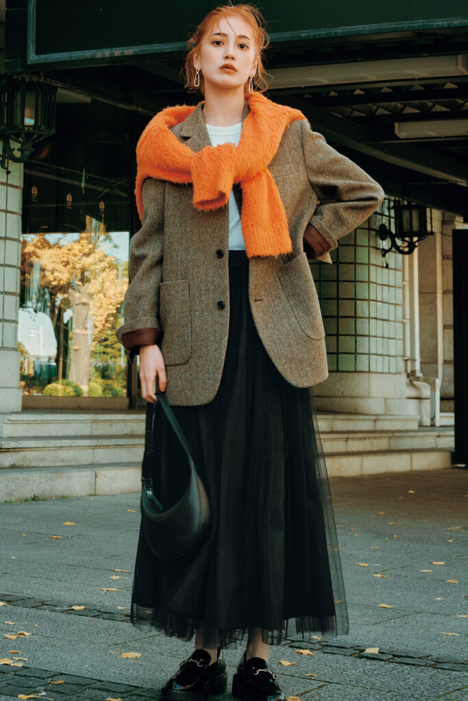 A tweed jacket styled with dark denim in an autumn street style look