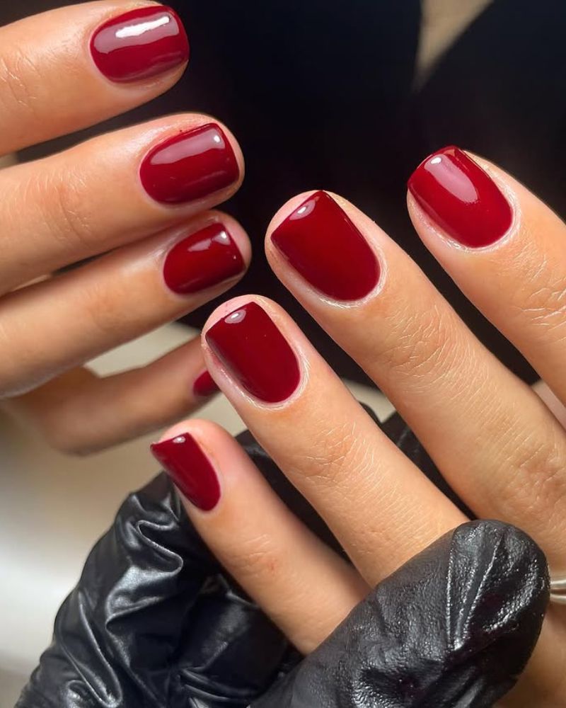 Short oval nails in classic high-gloss cherry red polish