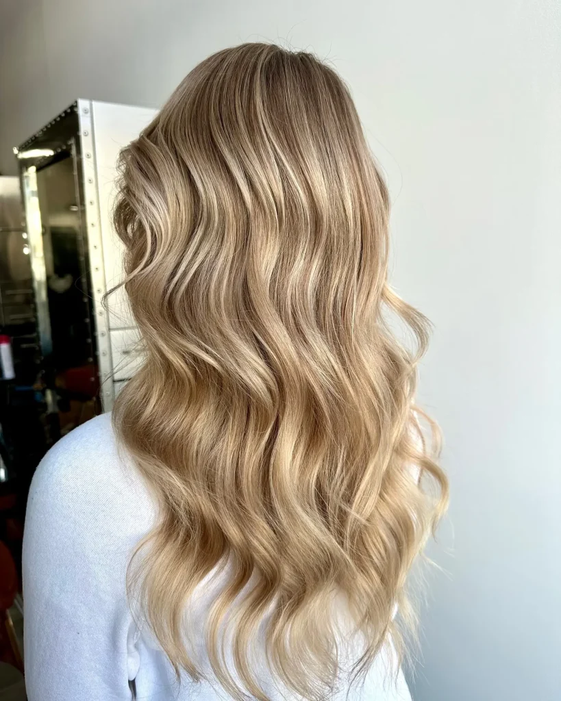 Long blonde beach waves with a center part, salon styling