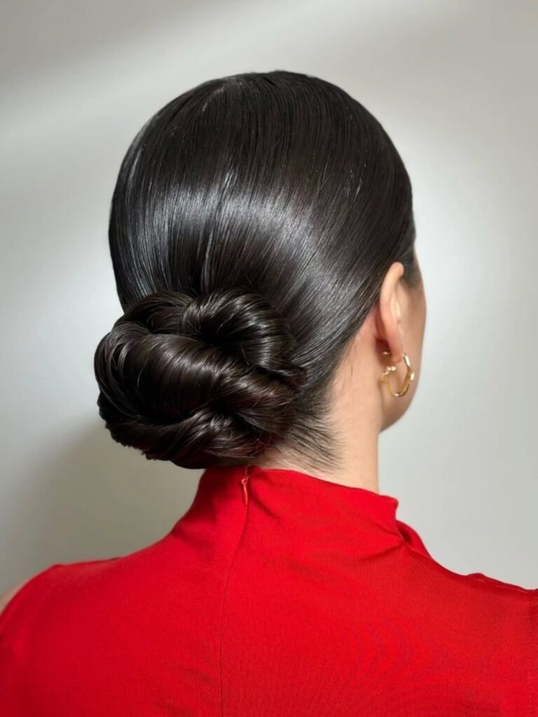 Back view of a sleek, polished slicked-back low chignon on black hair — exact office-look match.