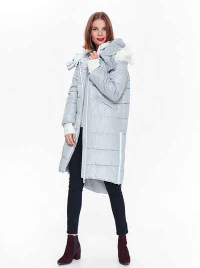 Woman in burgundy suede ankle boots, black leggings and a long grey quilted puffer coat