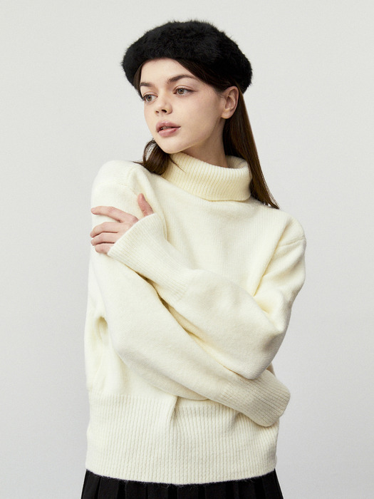 Woman wearing a cream beret with a cozy knit outfit