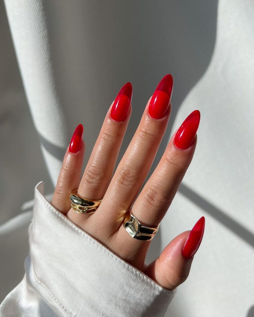 Sheer translucent red jelly nails in a glossy almond shape