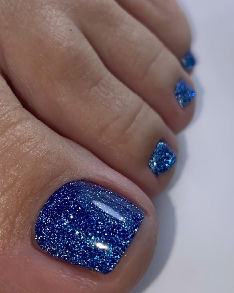 Toenails with dense sapphire blue glitter polish