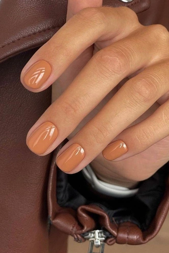 Short rounded nails in a warm caramel brown-nude shade