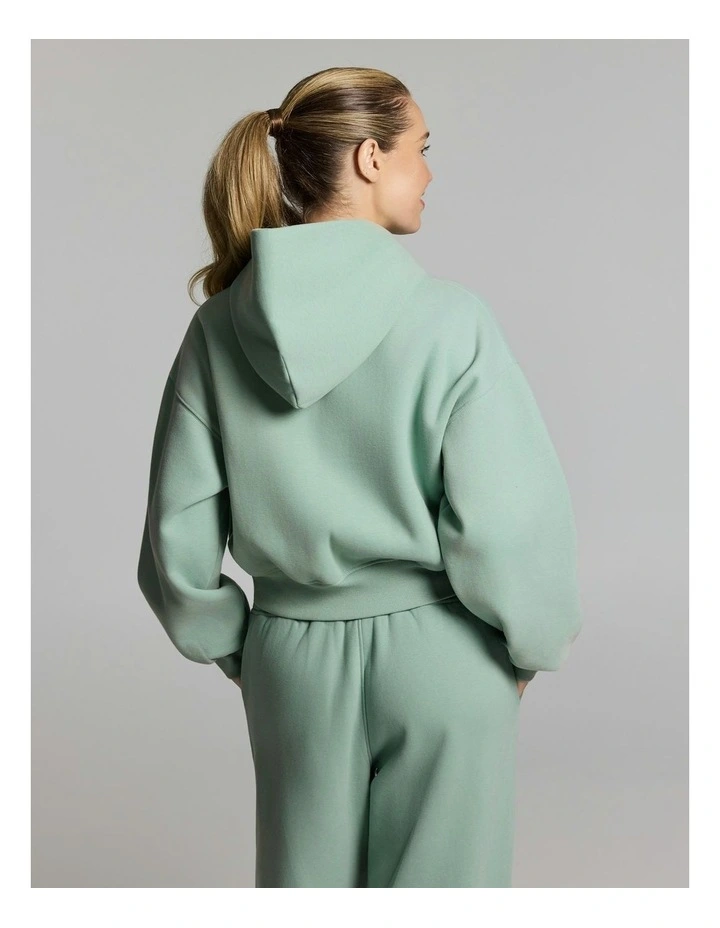 Woman seen from behind wearing a mint green hoodie and matching sweatpants