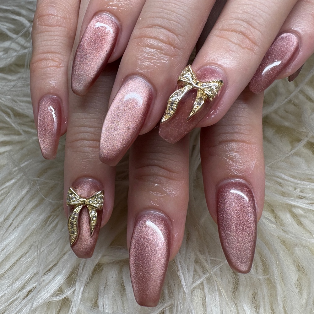 Mauve shimmer nails with gold jeweled bow charms