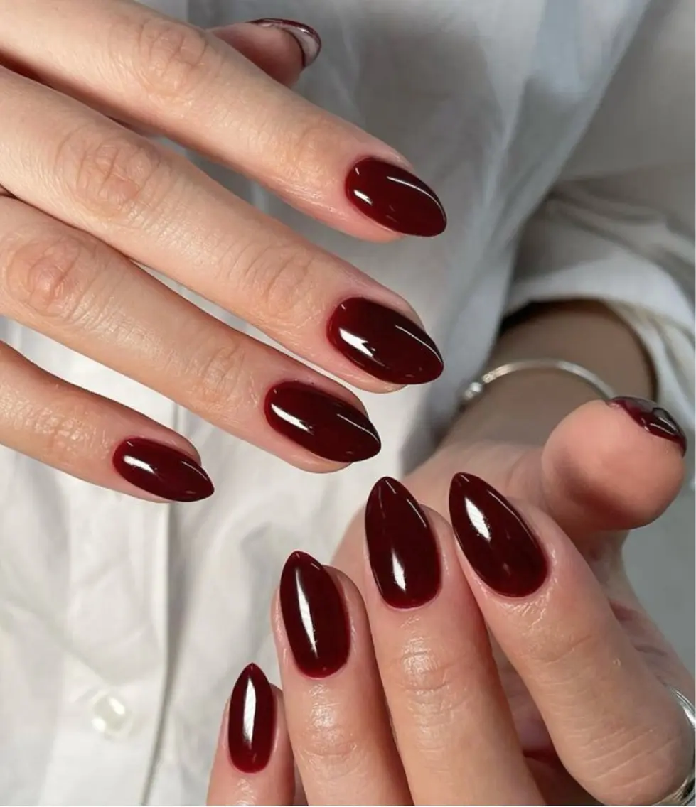 Medium-length almond nails in high-gloss deep burgundy-wine solid polish.