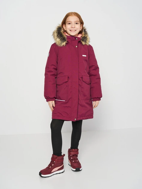 A girl wearing a quilted parka with leggings and snow boots in winter