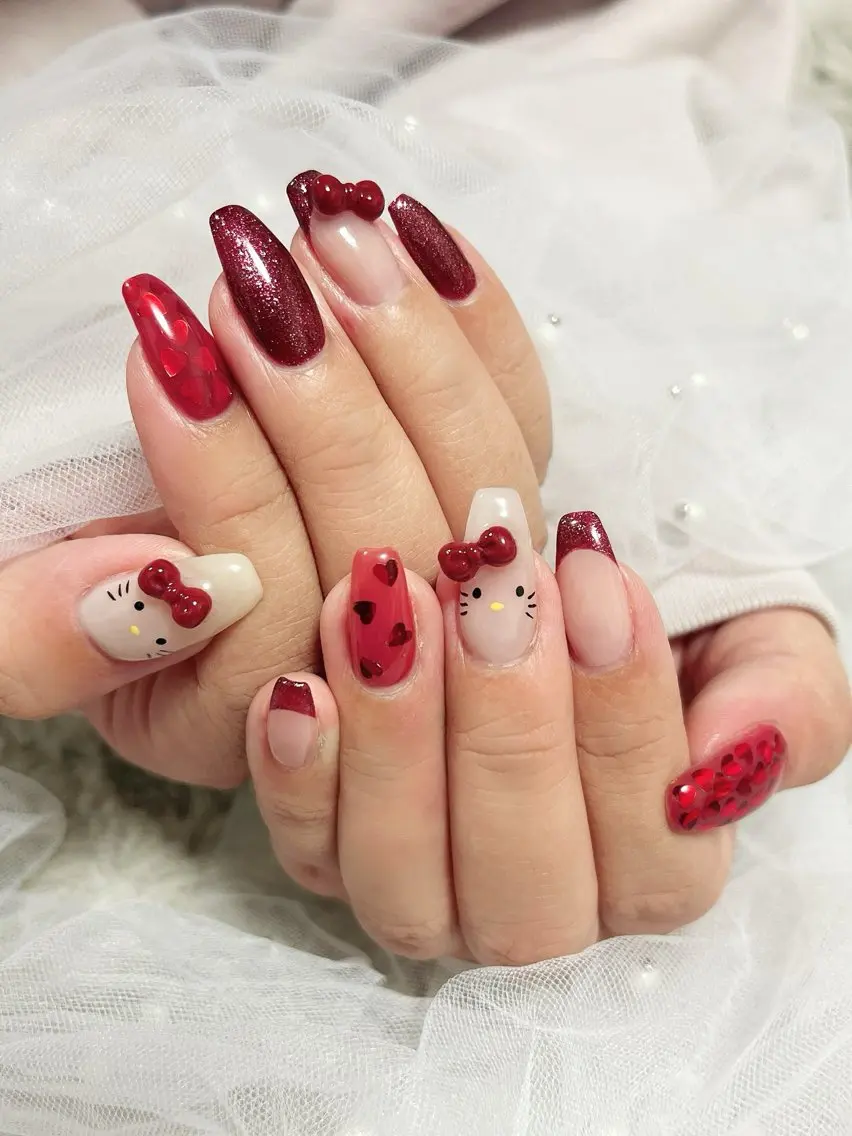 Long coffin nails in burgundy glitter with red heart confetti, Hello Kitty faces with 3D burgundy bows on white accent nails