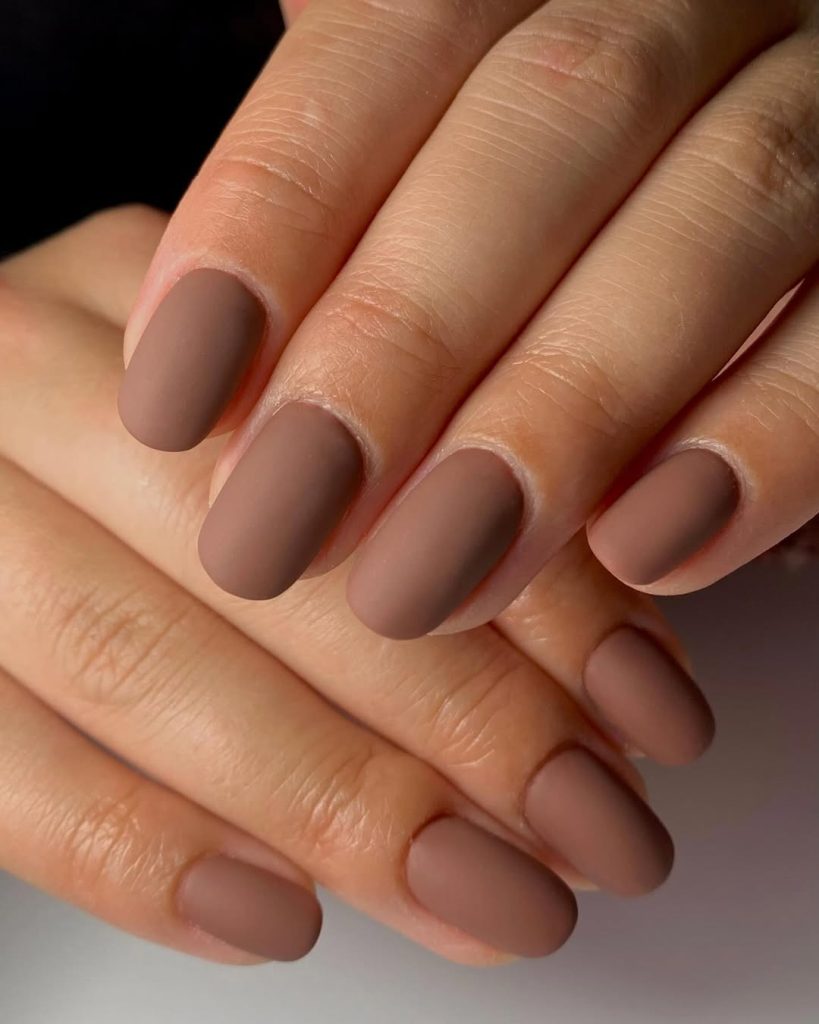 Matte mushroom-taupe polish on almond-shaped nails