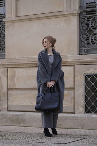 Woman in a long grey teddy coat with grey layers