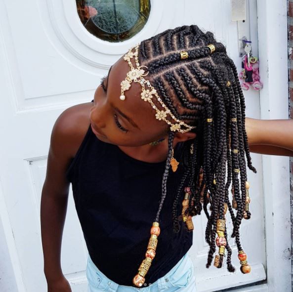 Child wearing Fulani braids decorated with beads and hair cuffs