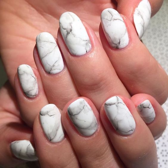 Almond-shaped nails with soft grey marble veining over a pale base