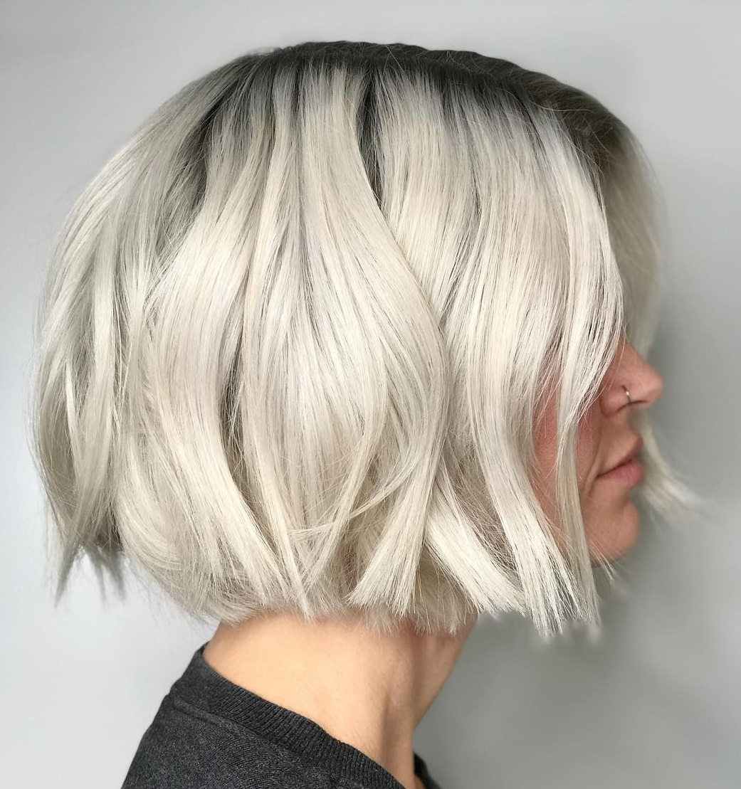 Choppy bob with dark shadow roots blending into platinum ends