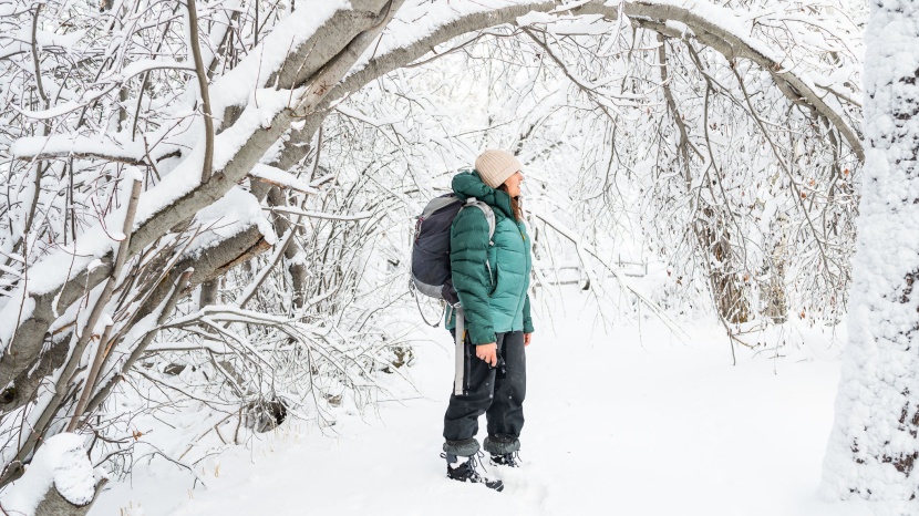 Woman wearing a down jacket and hiking boots on a winter trail