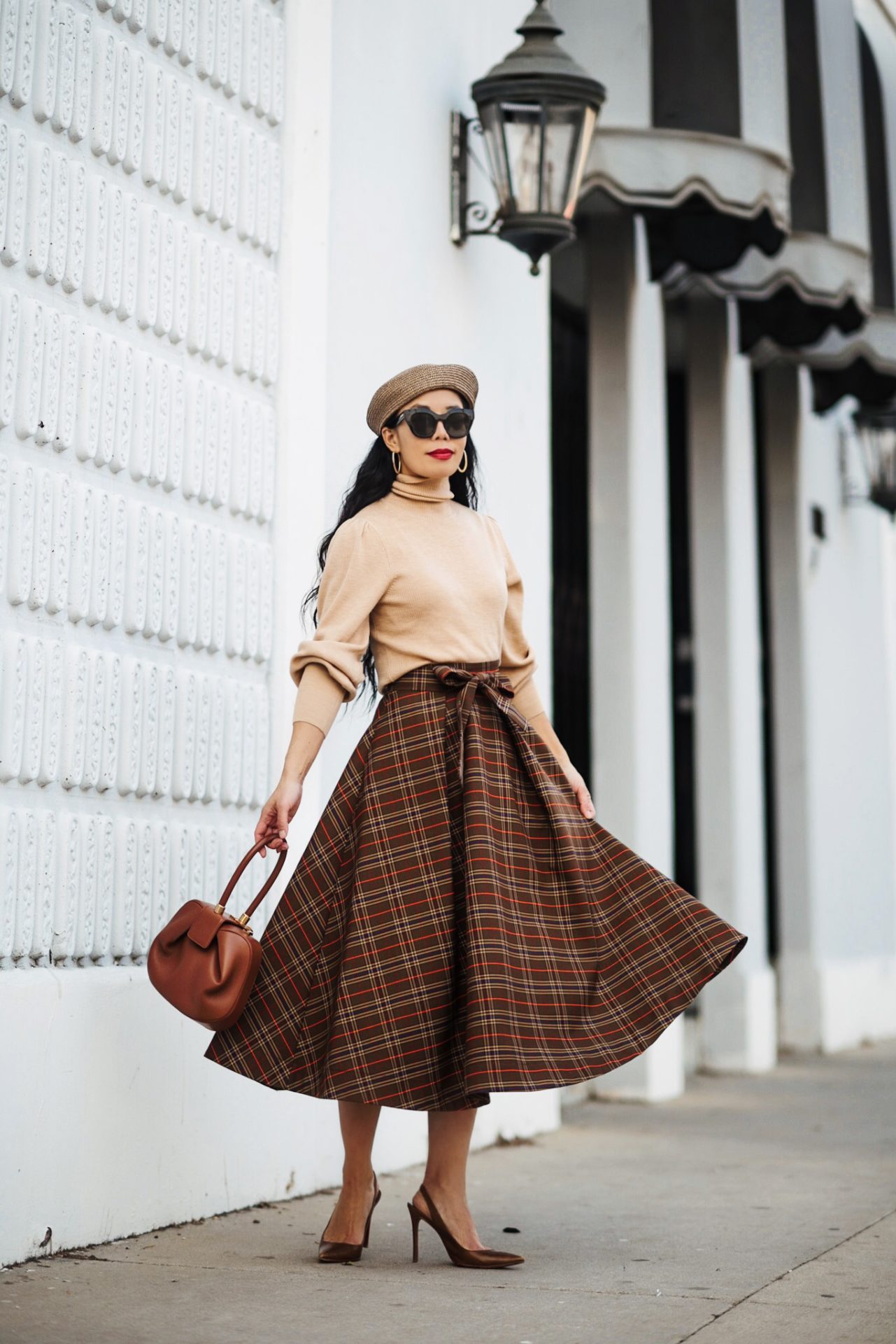 Woman wearing a brown plaid circle midi skirt, camel turtleneck, brown beret and brown slingback heels