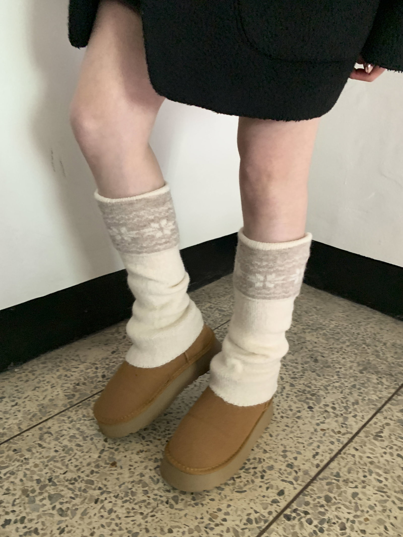 Beige ribbed leg warmers with cream teddy shorts, a cream cable knit sweater and beige fuzzy slippers