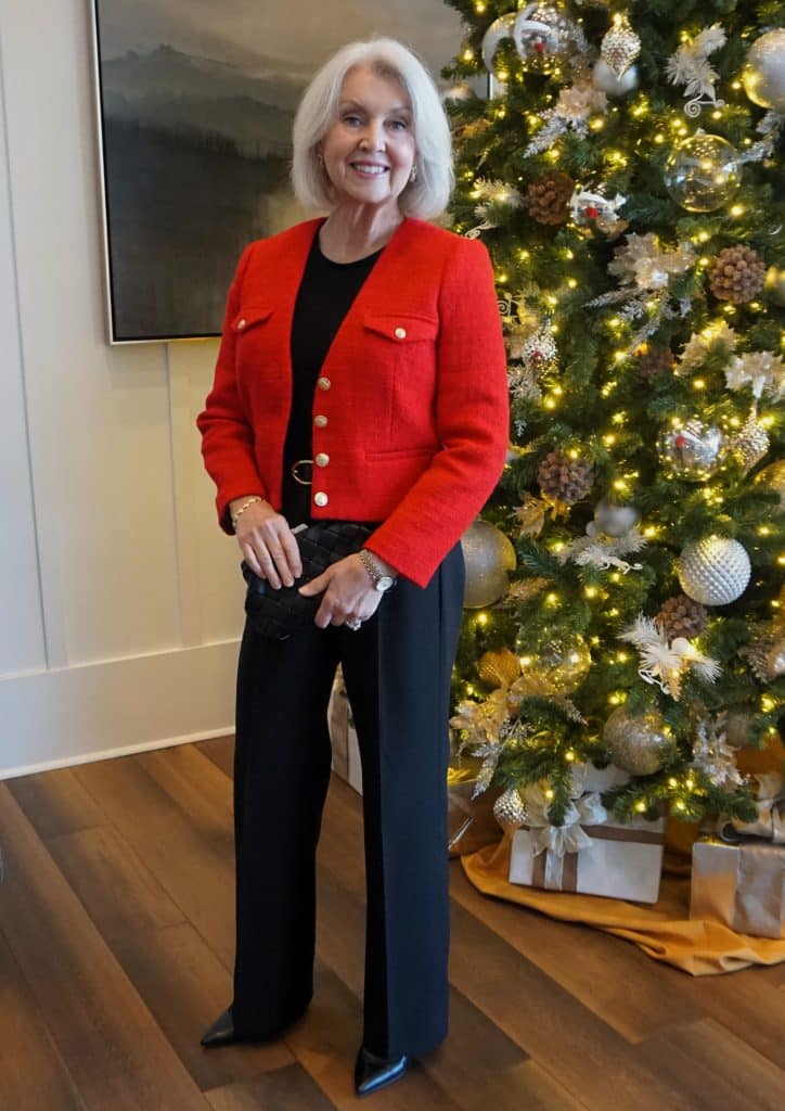 Senior woman in a rich red sweater with a black velvet midi skirt and gold earrings