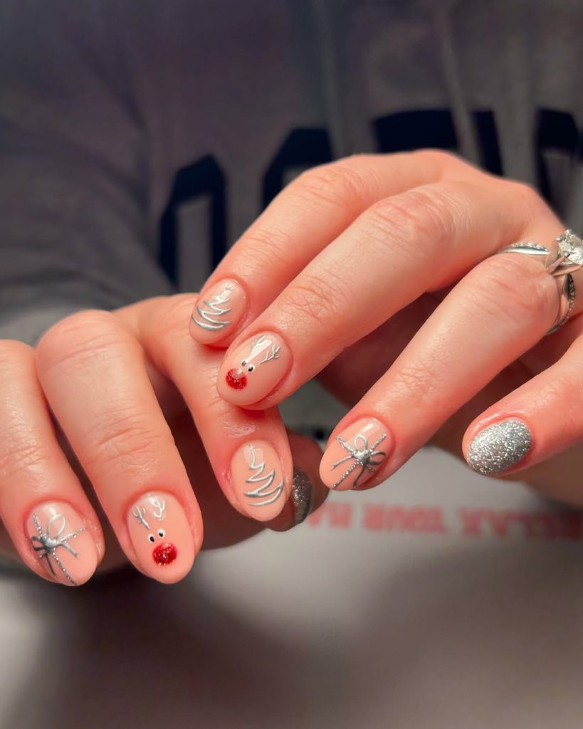 Short nude Christmas nails with silver reindeer, bow and tree nail art