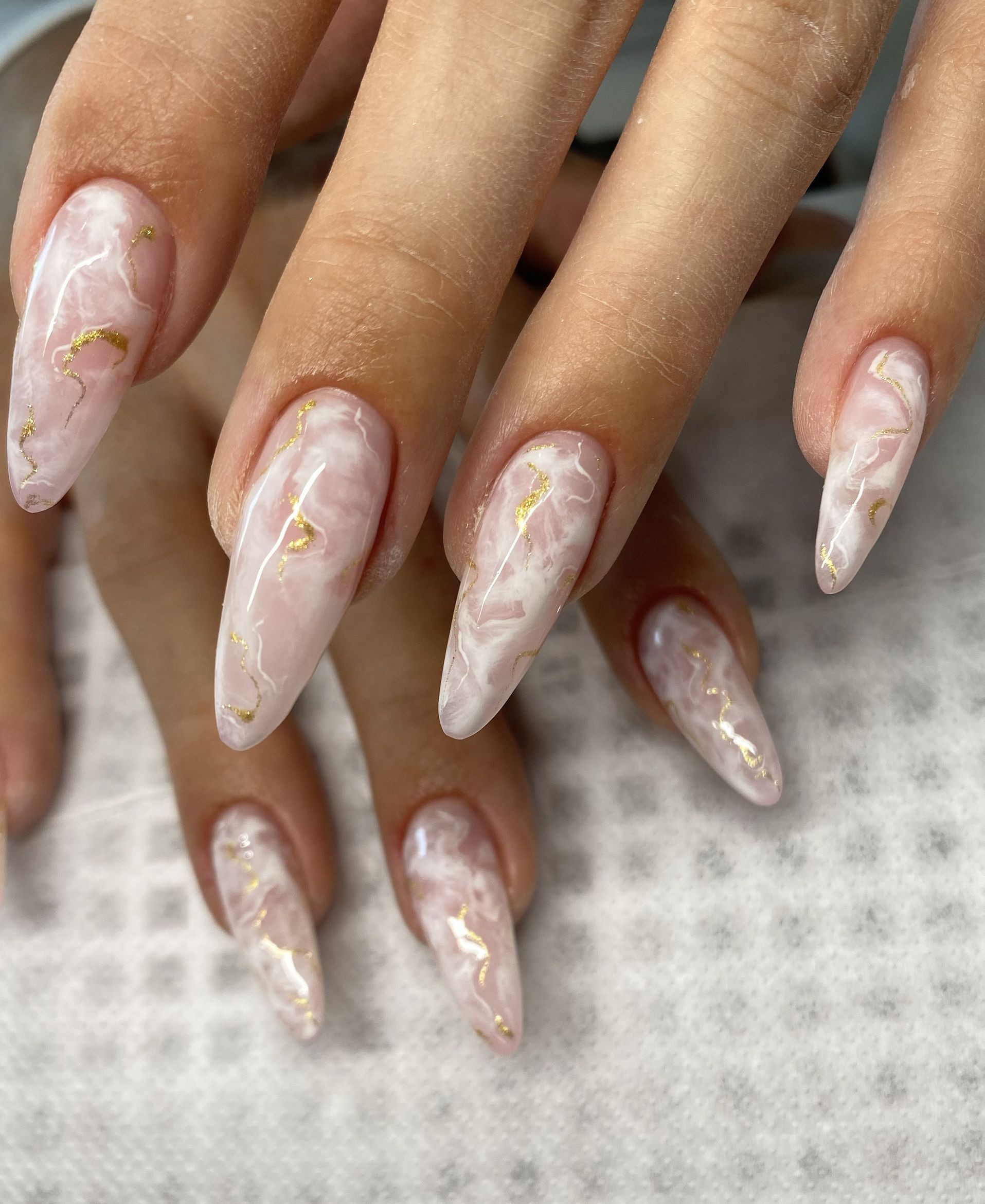 Soft pink marble nails on almond-shaped tips