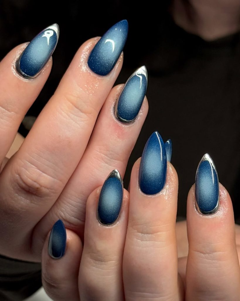 Medium almond midnight blue aura nails with a shimmering halo center and silver chrome outline
