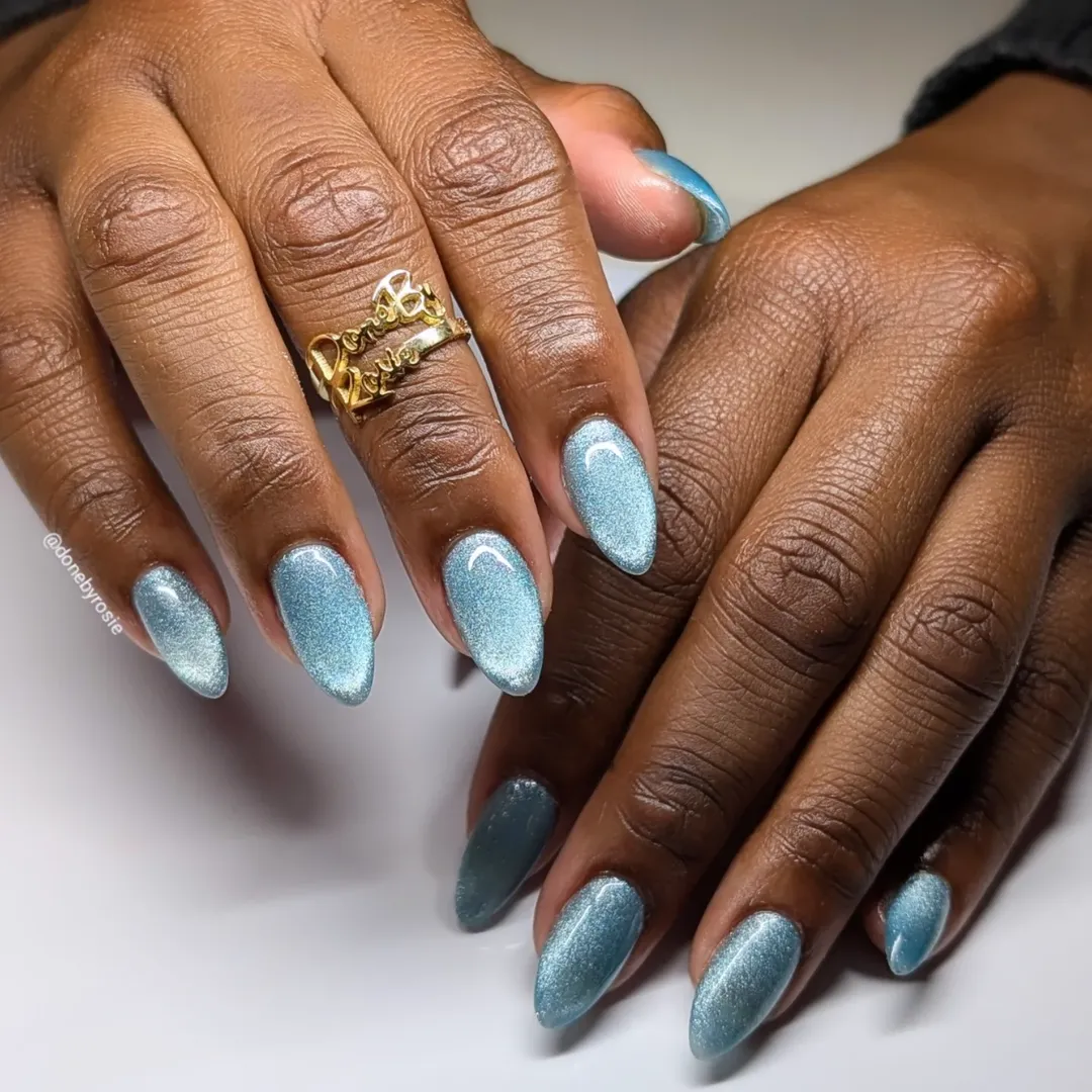 Icy blue cat-eye almond nails on brown skin