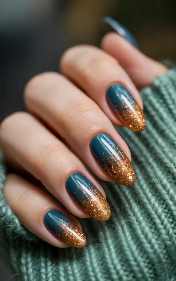 Medium almond nails with deep teal polish and a copper glitter ombre fading from the tips