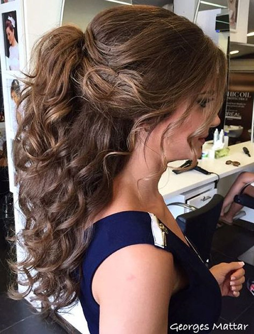 Voluminous half ponytail with bouncy curls, rest of hair down
