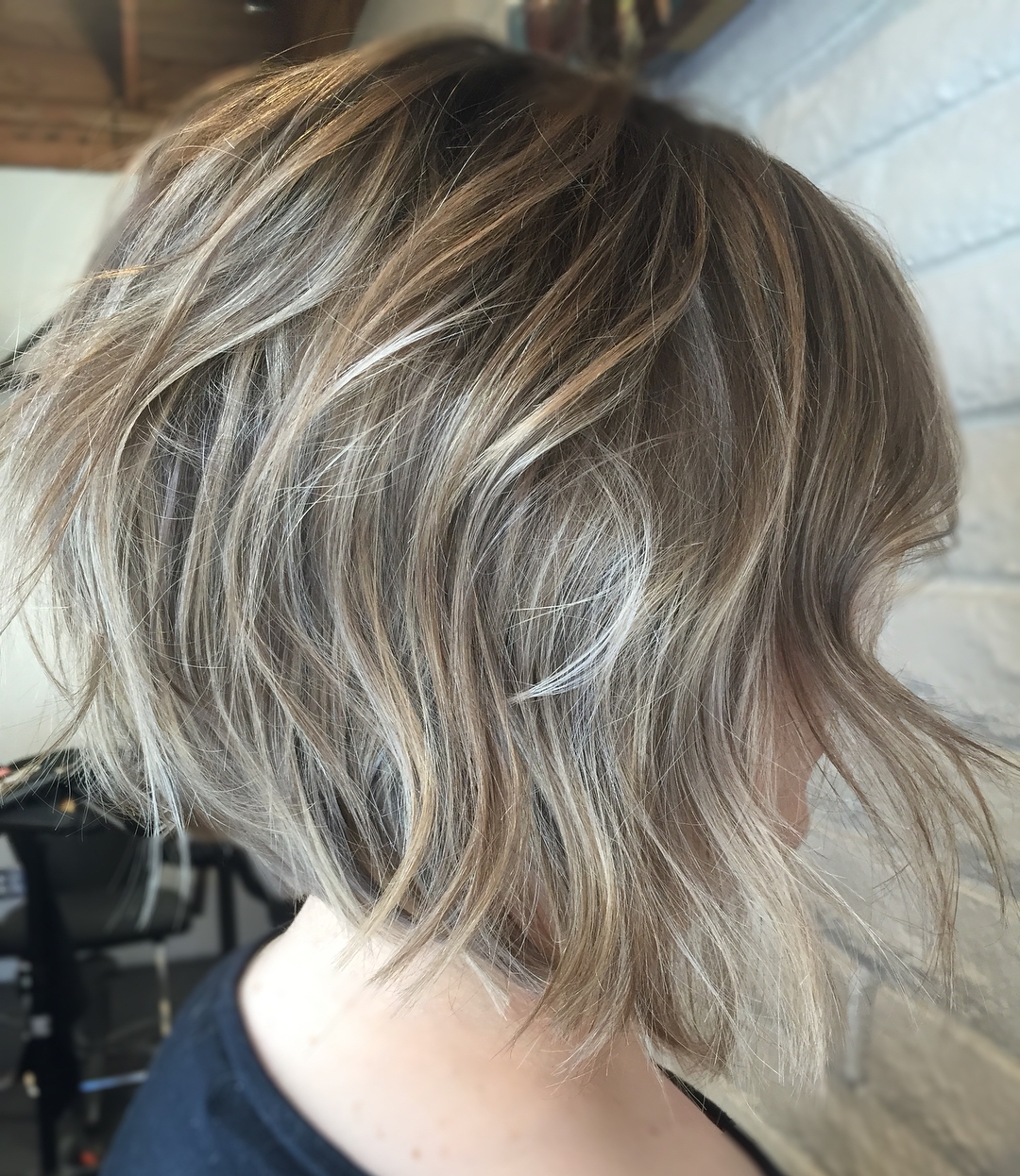 Wavy A-line bob with shaggy layers and blonde highlights