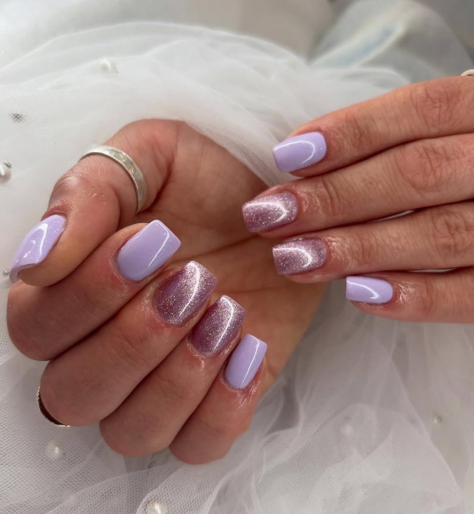 Short squoval nails in pale lilac creme polish with glittery lilac accent nails