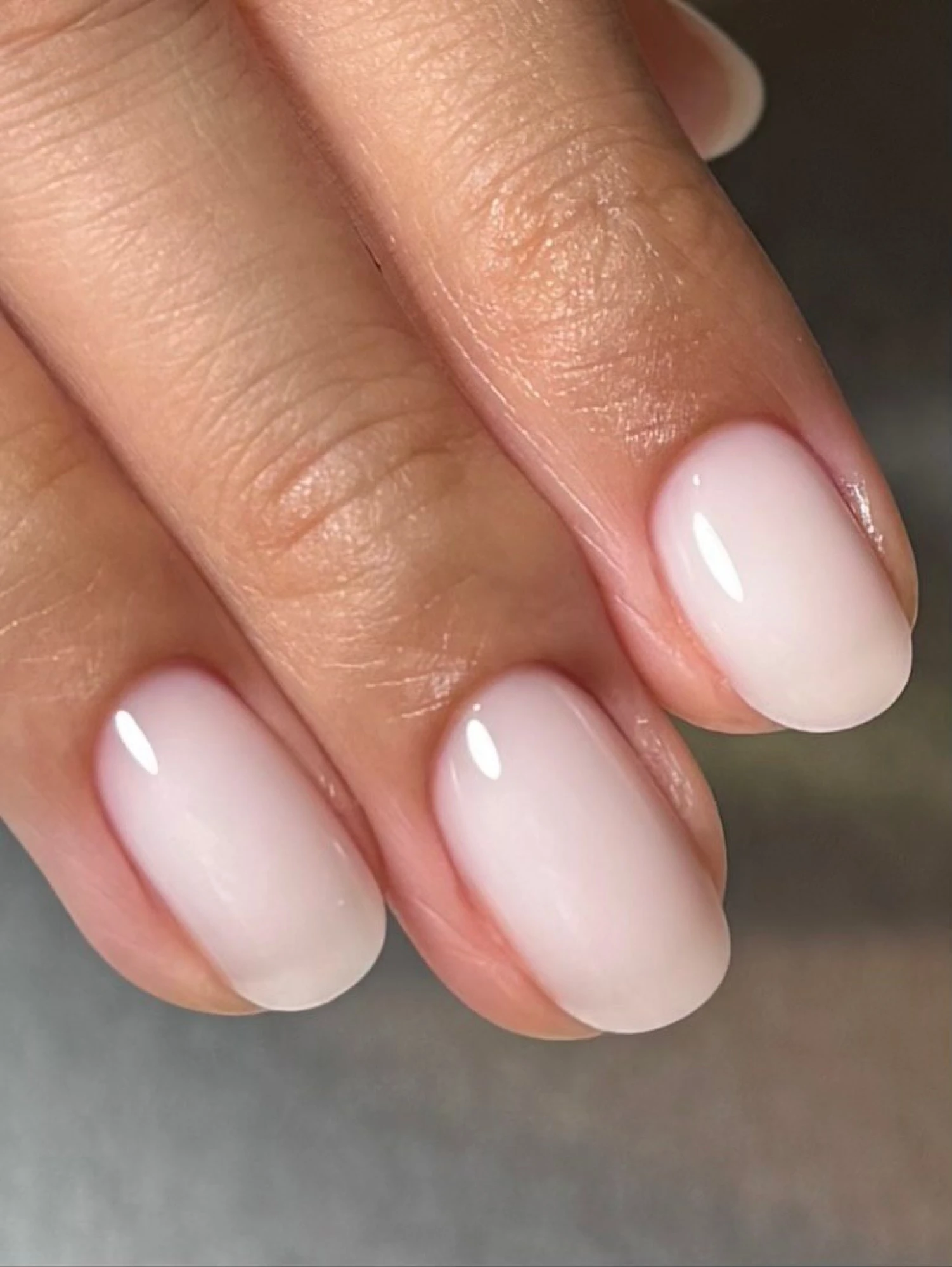 Short round nails with a sheer milky white wash