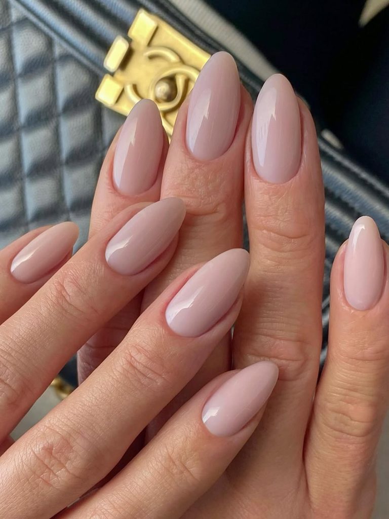 Medium almond nails in a warm taupe nude polish with glossy finish