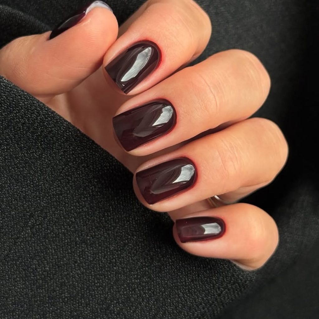 Glossy oxblood red polish on short nails