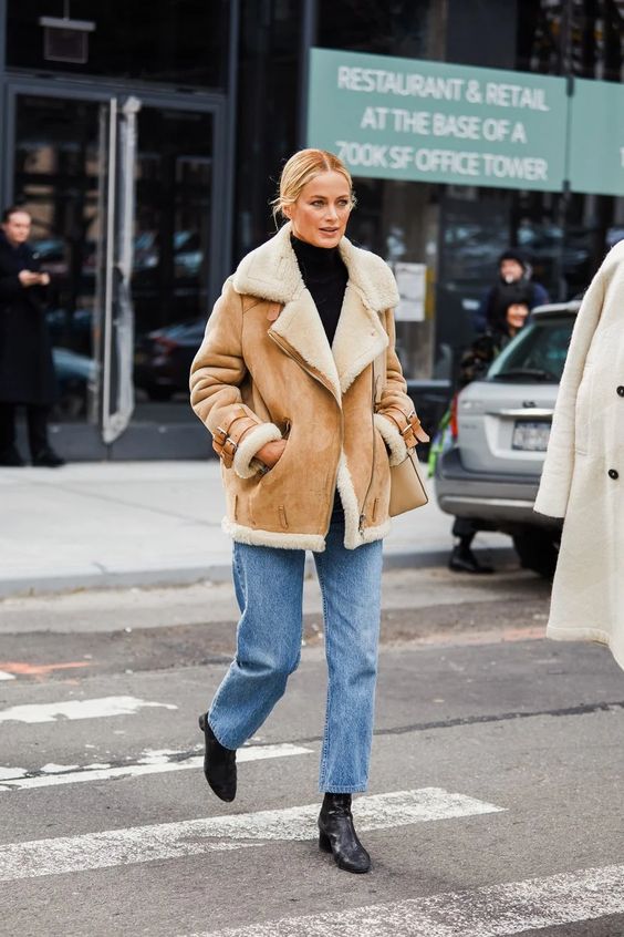 Woman wearing a shearling jacket with jeans and boots