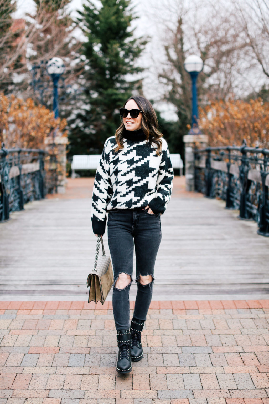 Woman wearing a patterned knit sweater, dark jeans and black combat boots winter outfit