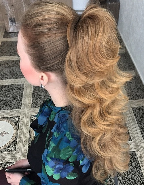High sleek ponytail falling into soft polished waves