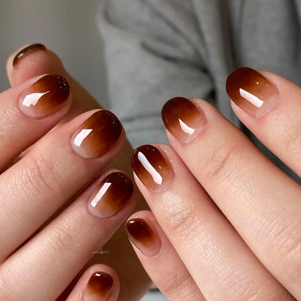 Short round nails with a nude-to-brown latte ombré gradient