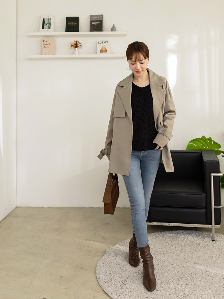Woman in brown slouchy mid-calf boots with skinny jeans, beige trench coat and brown bag