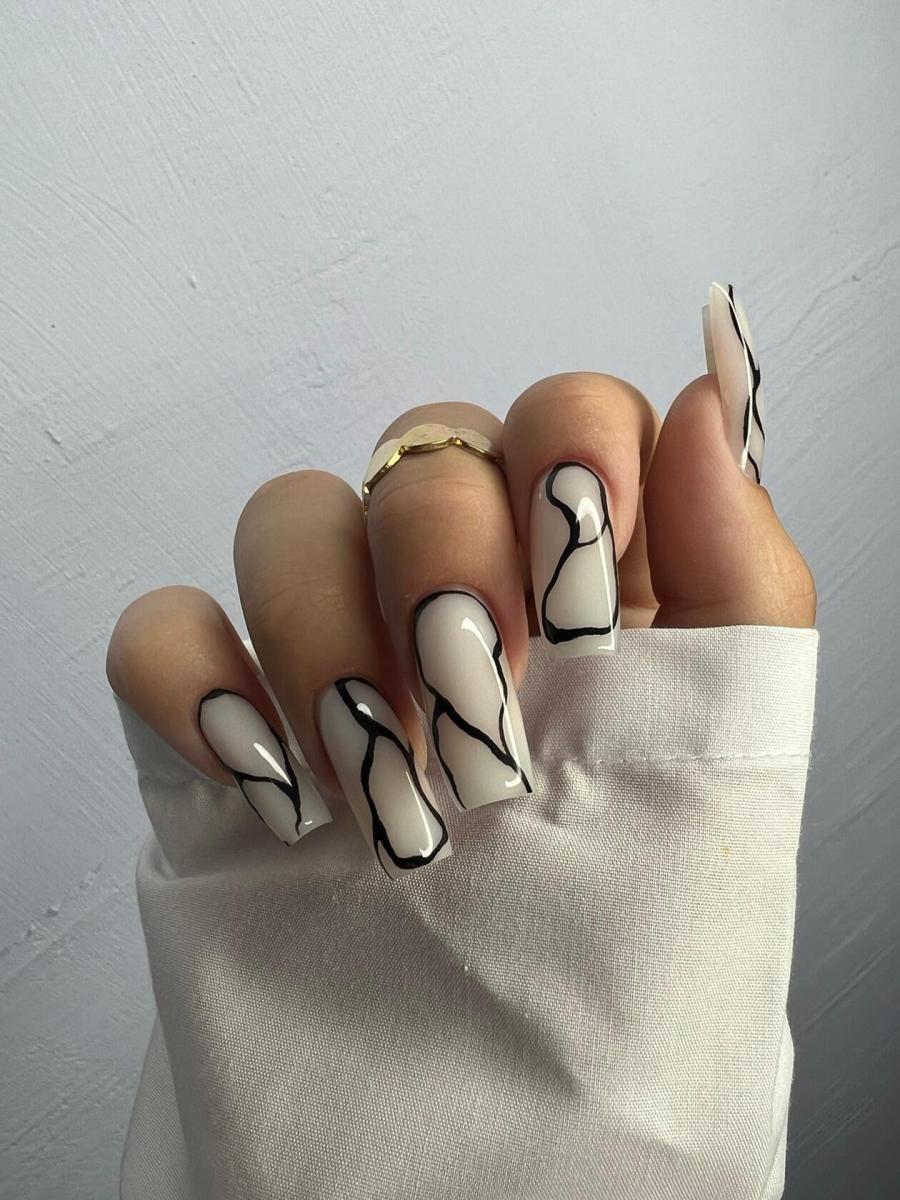 Long coffin nails in milky white with bold black wavy line art